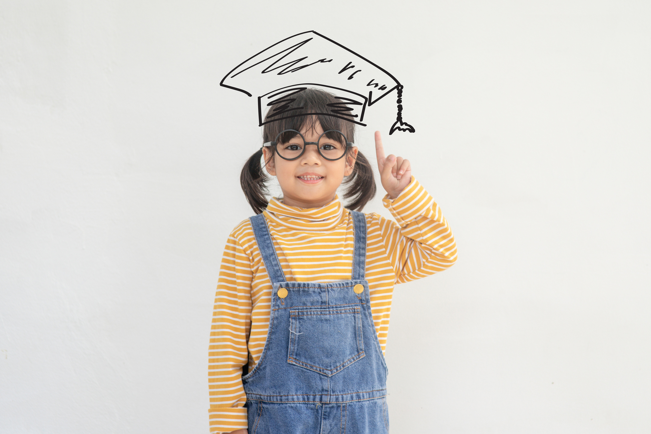 Happy Asian school kid graduate in graduation cap